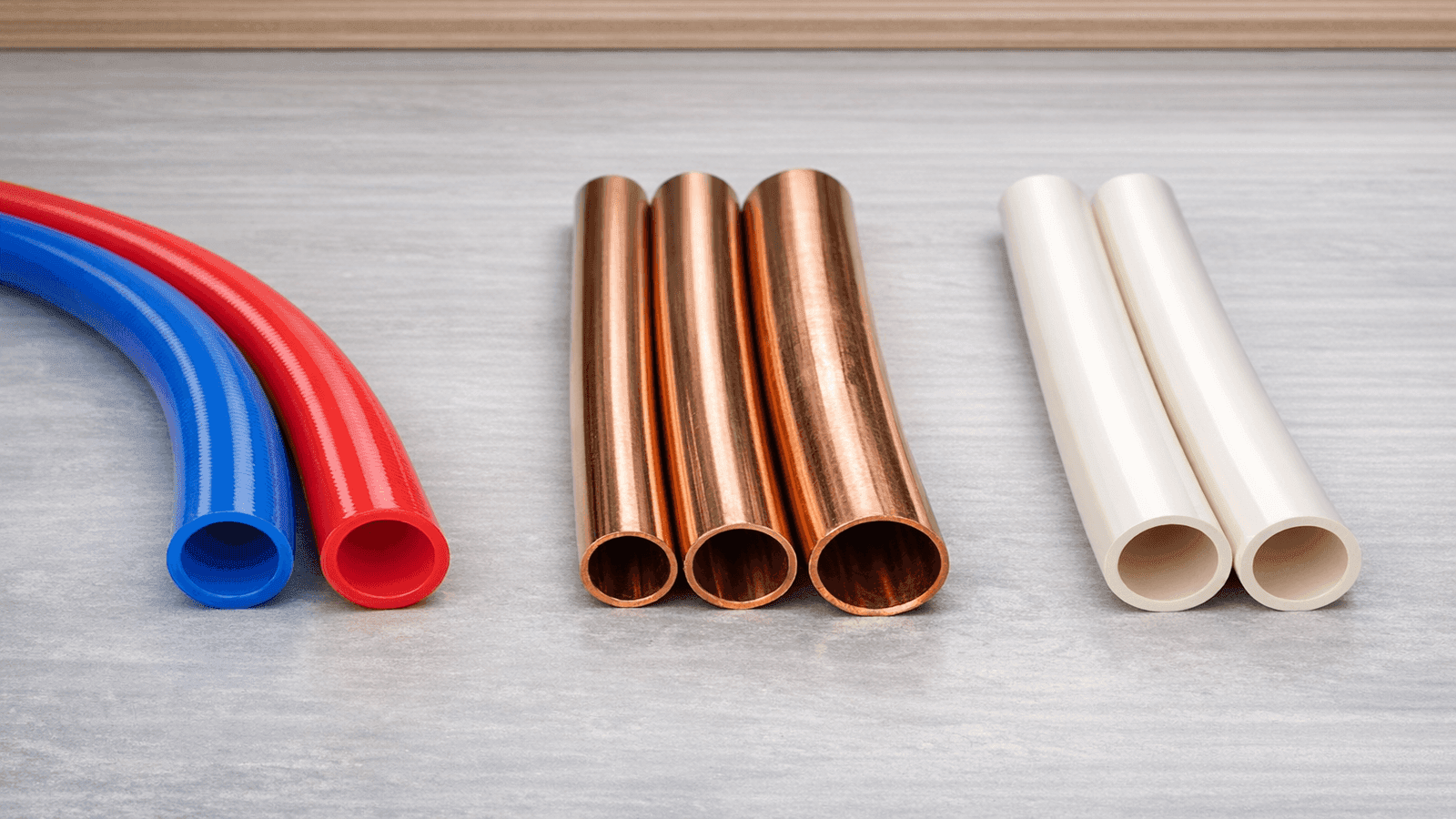Side-by-side comparison of PEX, copper, and CPVC plumbing pipes used for whole house repiping