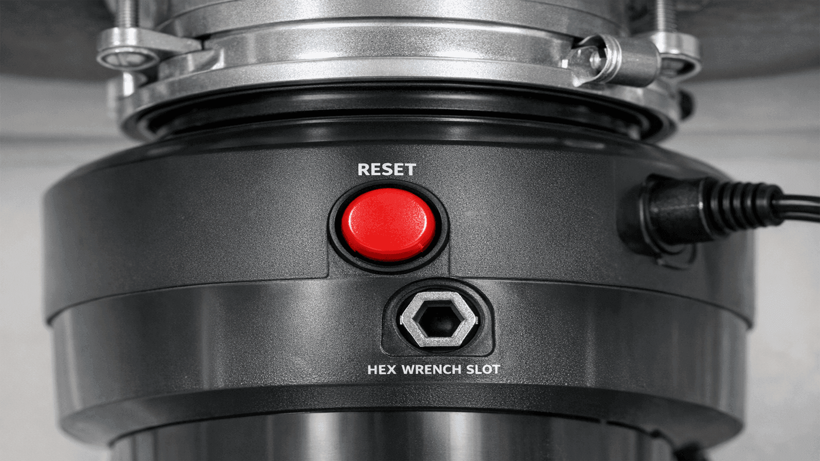 Bottom of garbage disposal showing red reset button